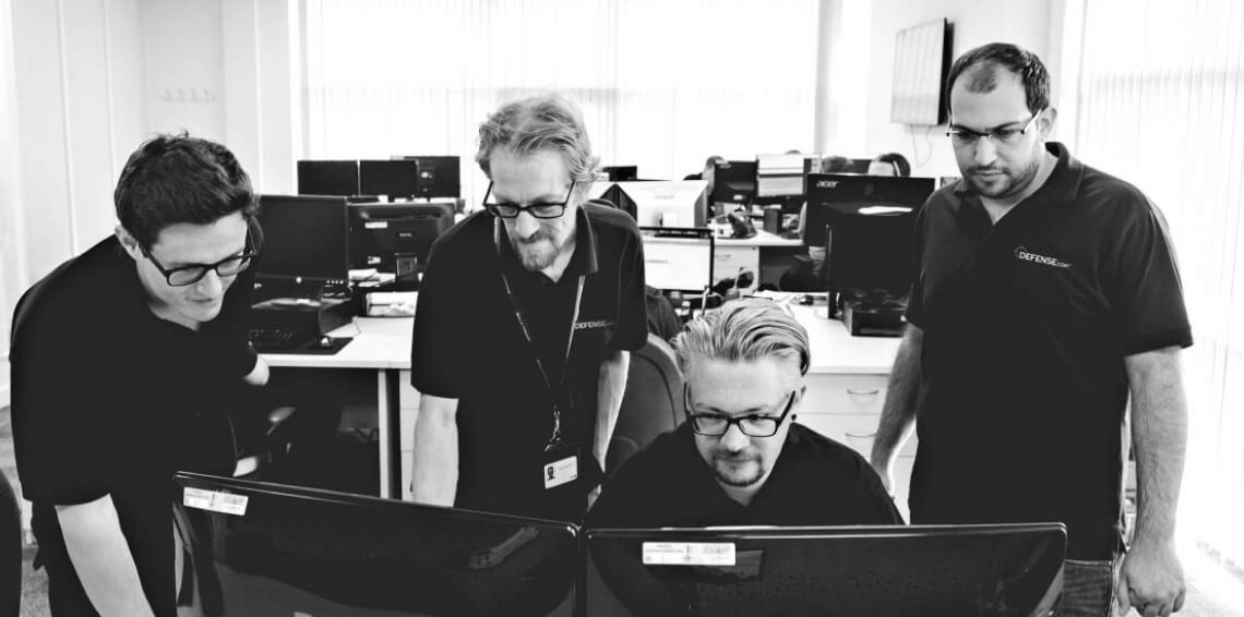 Defense.com engineers looking at a pc screen